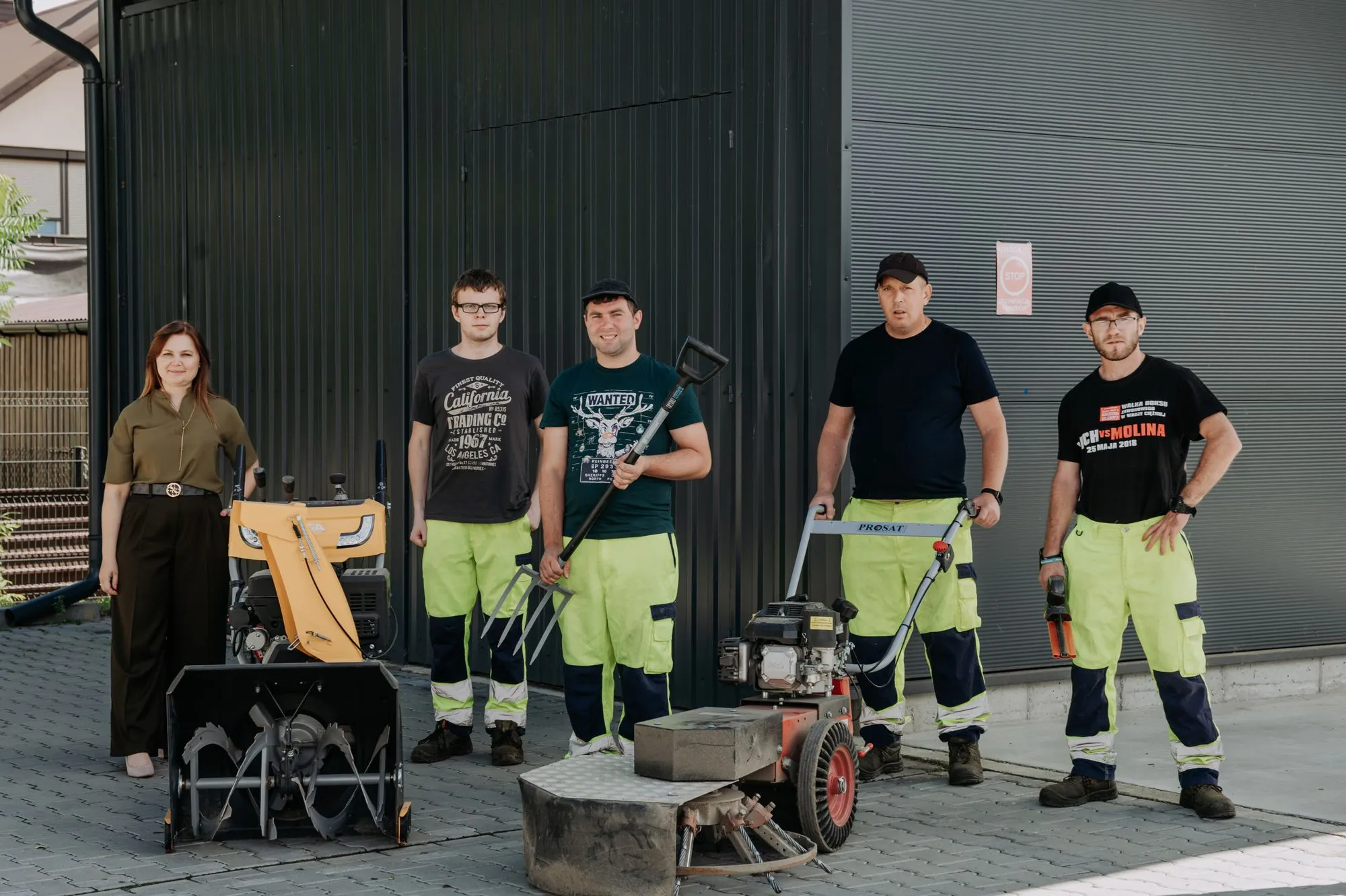 Zespół pracowni ogrodniczo-porządkowej PZAZ ze sprzętem przed budynkiem zakładu