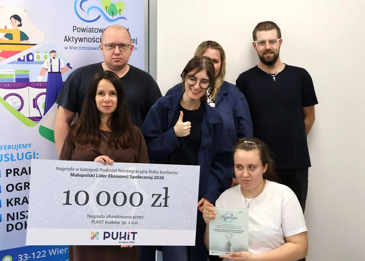 Pięcioro pracowników PZAZ przy roll-upie Zakładu z symbolicznym czekiem na 10 000 zł i dyplomem konkursu, jedna osoba pokazuje kciuk w górę