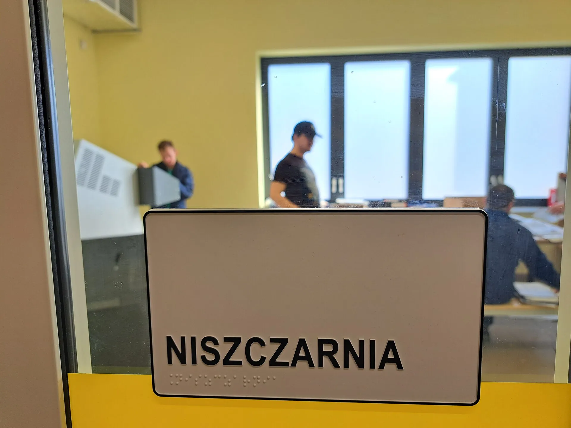 Tabliczka „Niszczarnia” na drzwiach pracowni, z napisem również w alfabecie Braille’a